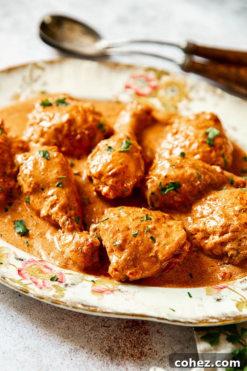 Velvety Hungarian Paprika Chicken 3 A close-up side view of perfectly braised chicken immersed in a velvety paprika sauce, ready to be served.