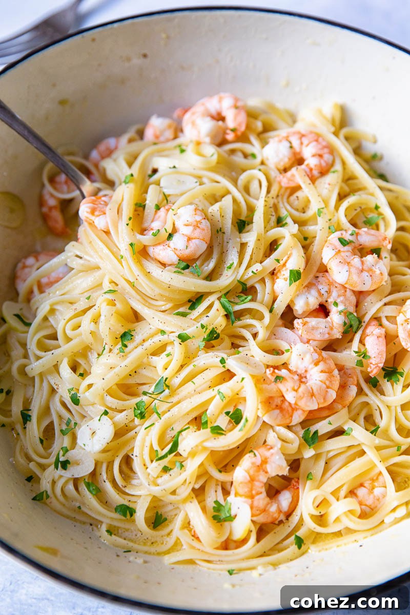 The pasta dish in a cast iron pan with a serving spoon