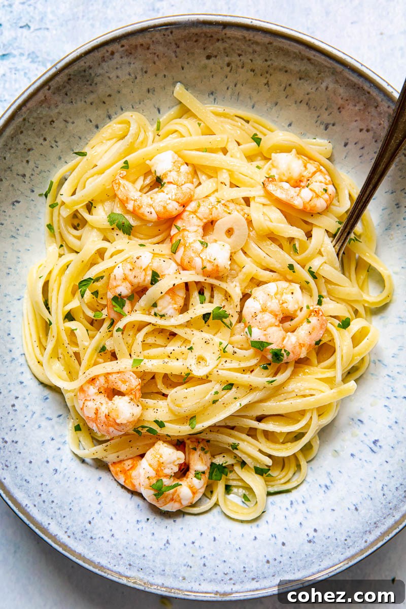Lemon Garlic Shrimp Linguine 4 A serving of Shrimp Scampi Linguine in a beautiful blue bowl, with a fork poised to twirl the pasta