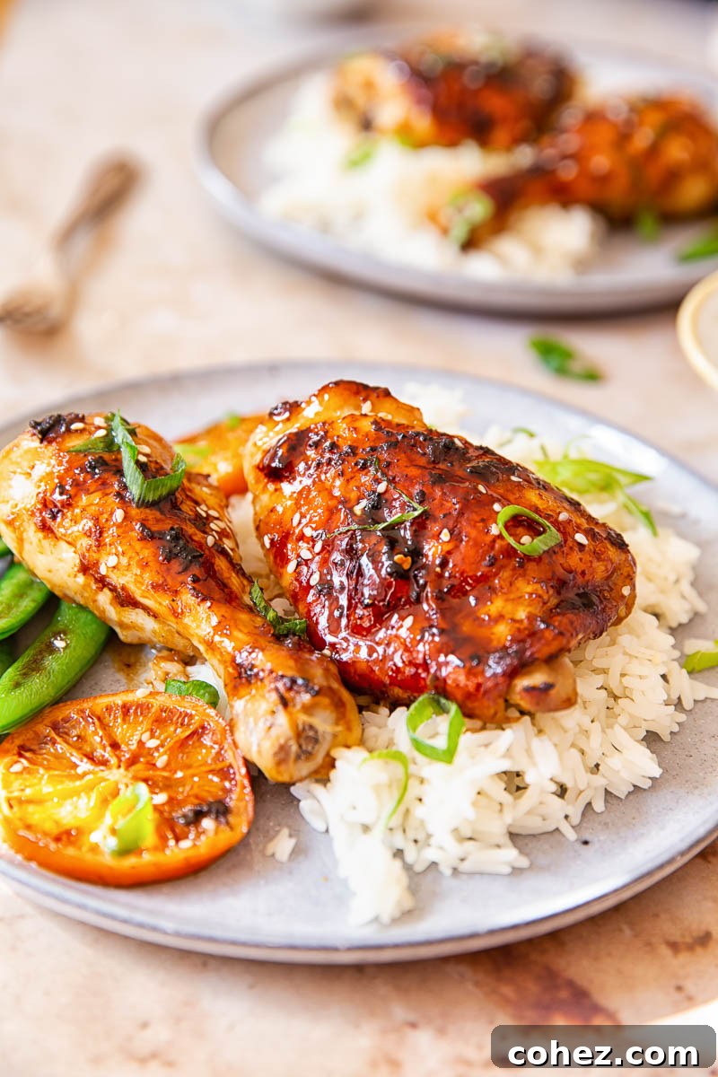 Sticky Honey Soy Glazed Chicken Thighs and Drumsticks 4 Honey Soy Chicken sprinkled with green onion and sesame seeds over white rice.