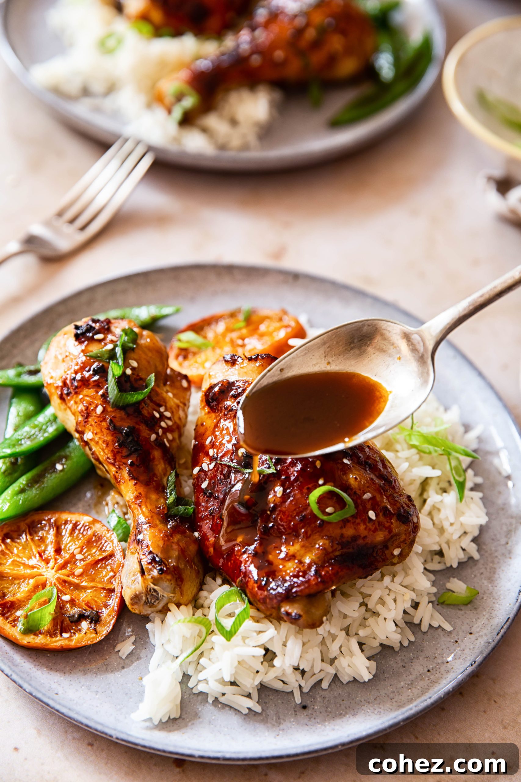 Sticky Honey Soy Glazed Chicken Thighs and Drumsticks 6 Honey Soy Chicken sprinkled with green onion and sesame seeds over white rice.