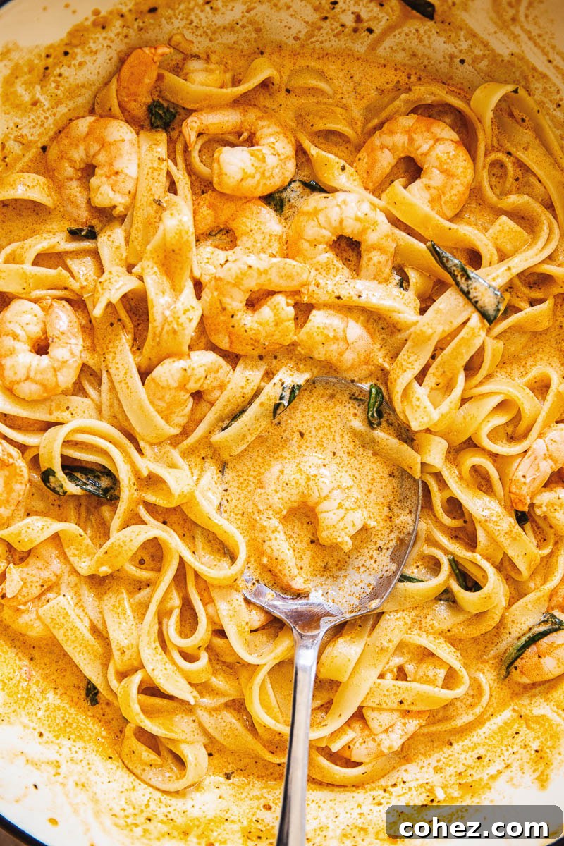 A bowl of shrimp pasta in creamy sun-dried tomato sauce, garnished with fresh herbs.