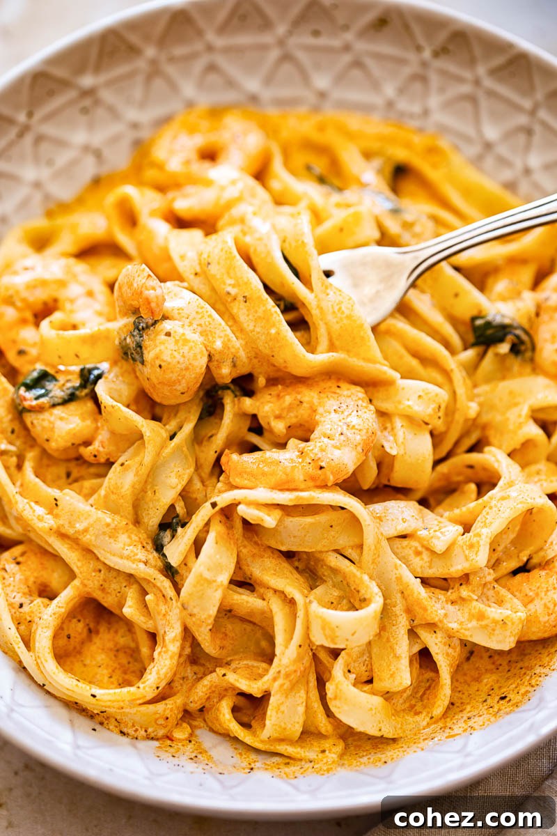 A plate of shrimp linguine in creamy sun-dried tomato sauce, garnished with basil.
