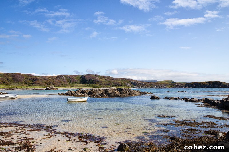 Mull: Where Scotland's Beauty Unfolds 2 Scenic beach with a white boat in the distance on the Isle of Mull