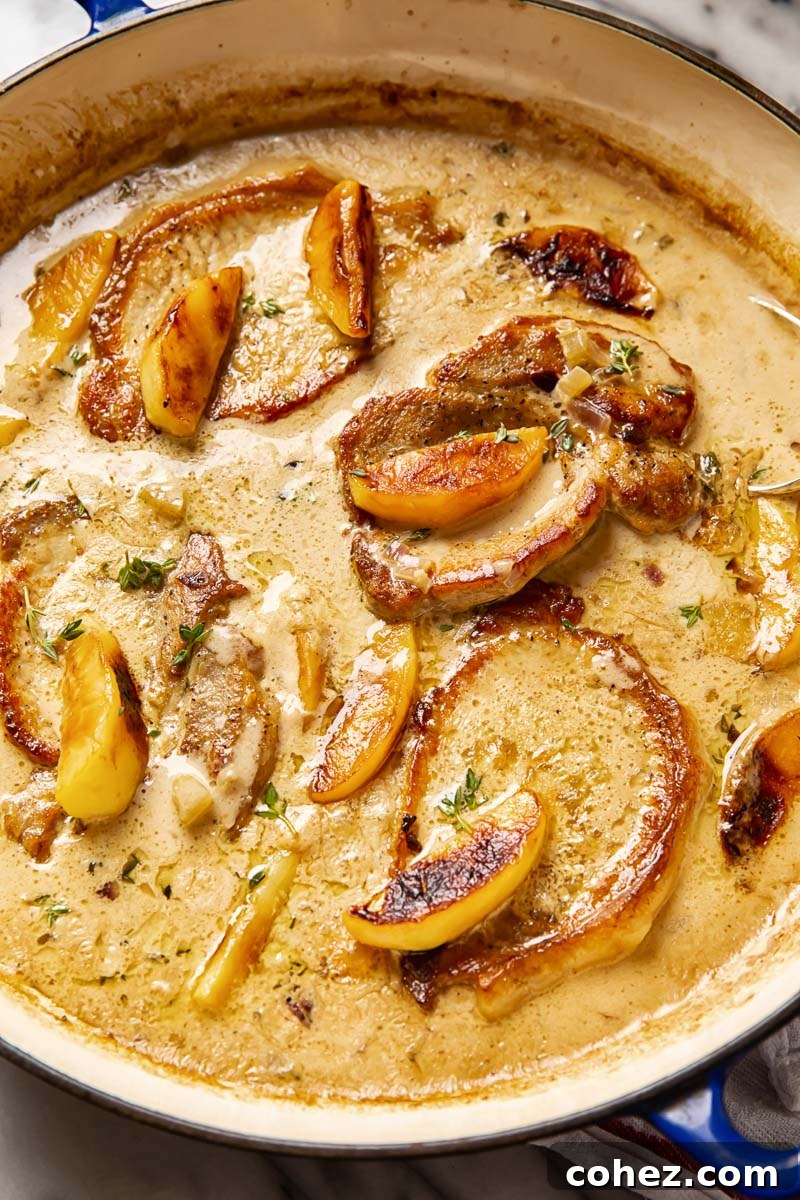 Tender and juicy boneless pork chops braised in apple cider with a splash of cream, served with apple slices