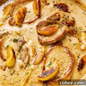 Pork chops and apples in creamy apple cider sauce in a cast iron pan