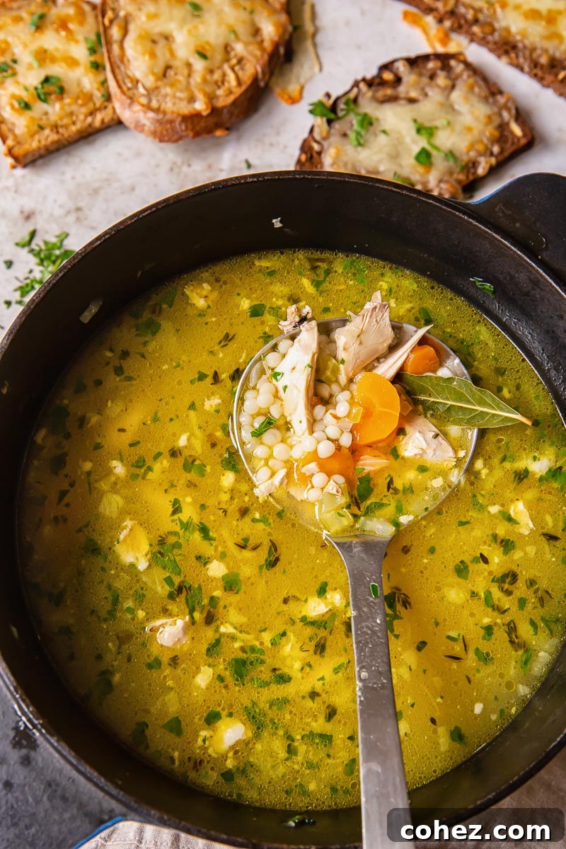 Turkey Soup simmering in a pot with visible giant couscous, ready to be served.