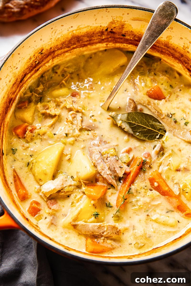 Leftover Turkey's Cozy Comeback Stew 2 Creamy turkey stew with carrots and potatoes in a rustic soup pot, ready to be served on a chilly night.