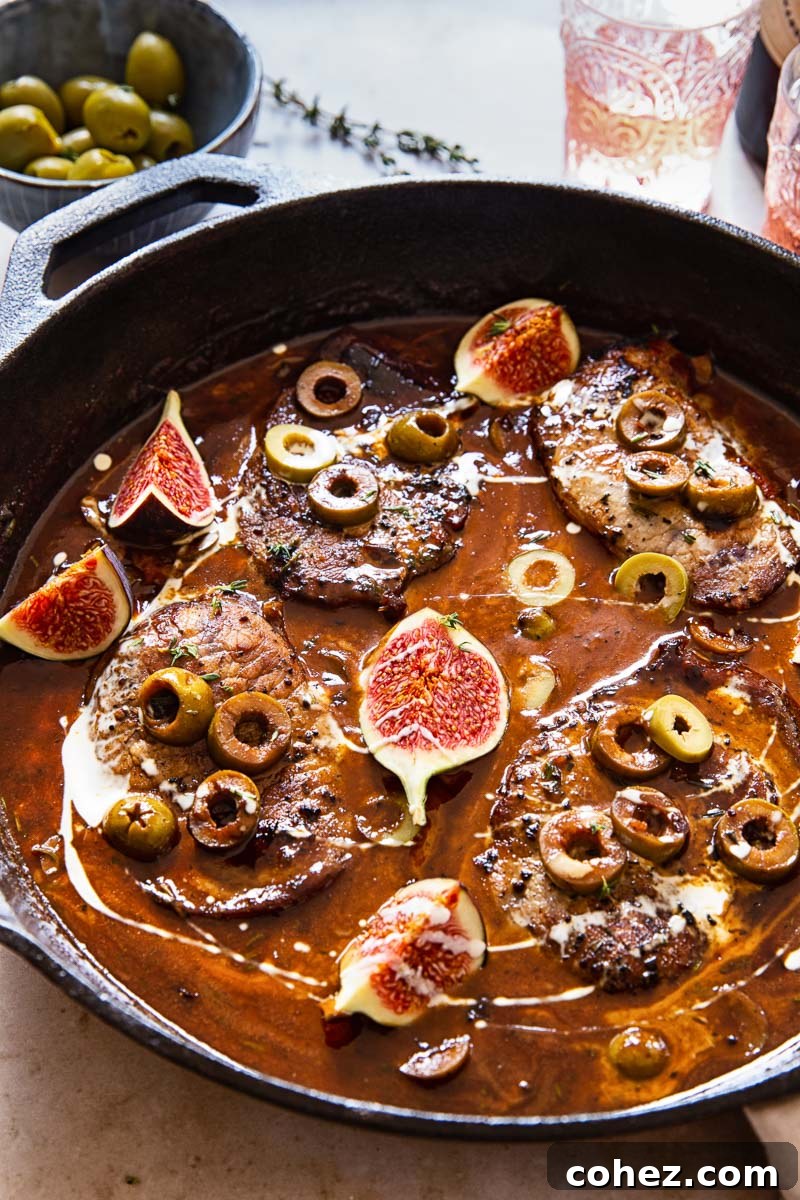 Juicy sweet and sour pork chops nestled in a creamy, tangy sauce, adorned with vibrant olives and delicate fig slices.
