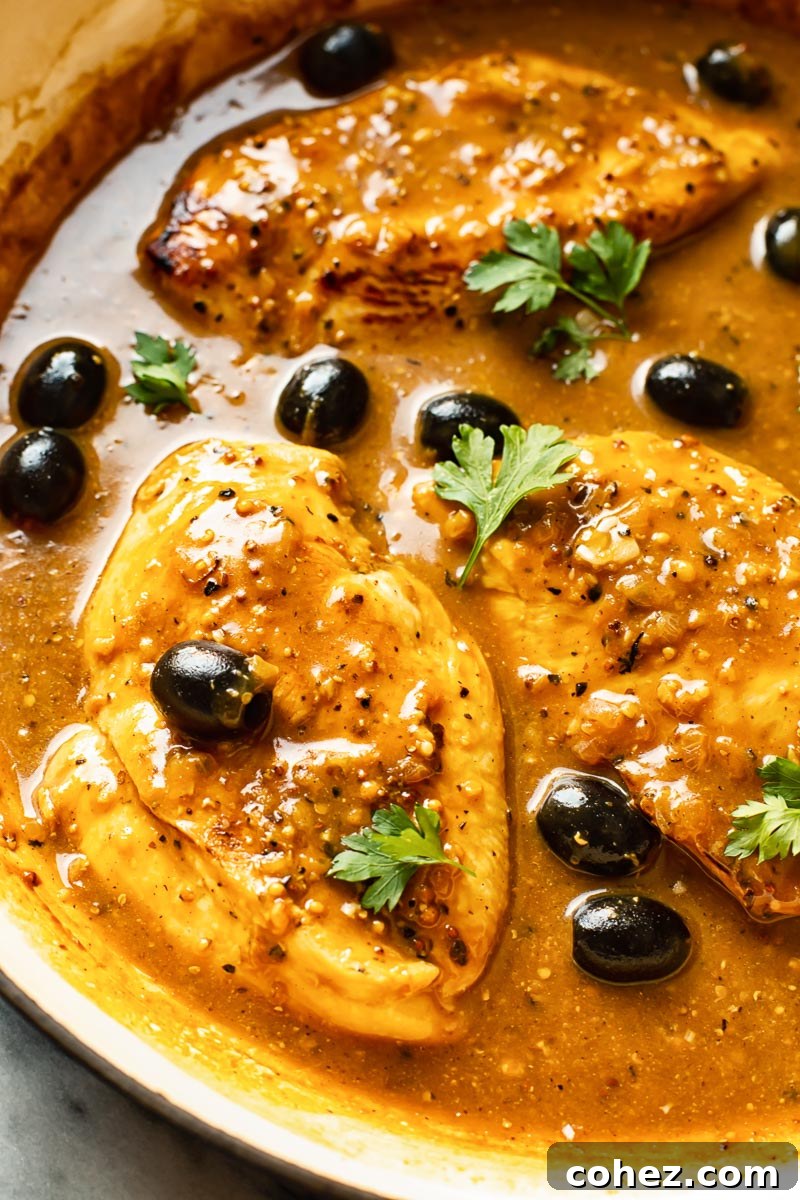 Plated lemon pepper chicken breasts drizzled with sauce, ready to be served.