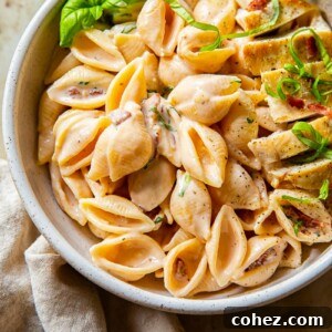 creamy bacon pasta topped with chicken breast and basil