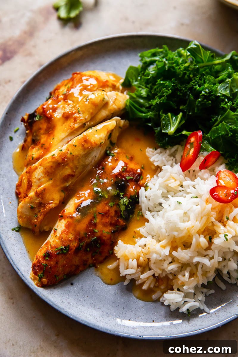 Close-up of glazed chicken breast, alongside aromatic rice and fresh kale on a grey plate, showcasing a delicious Instant Pot chicken meal.
