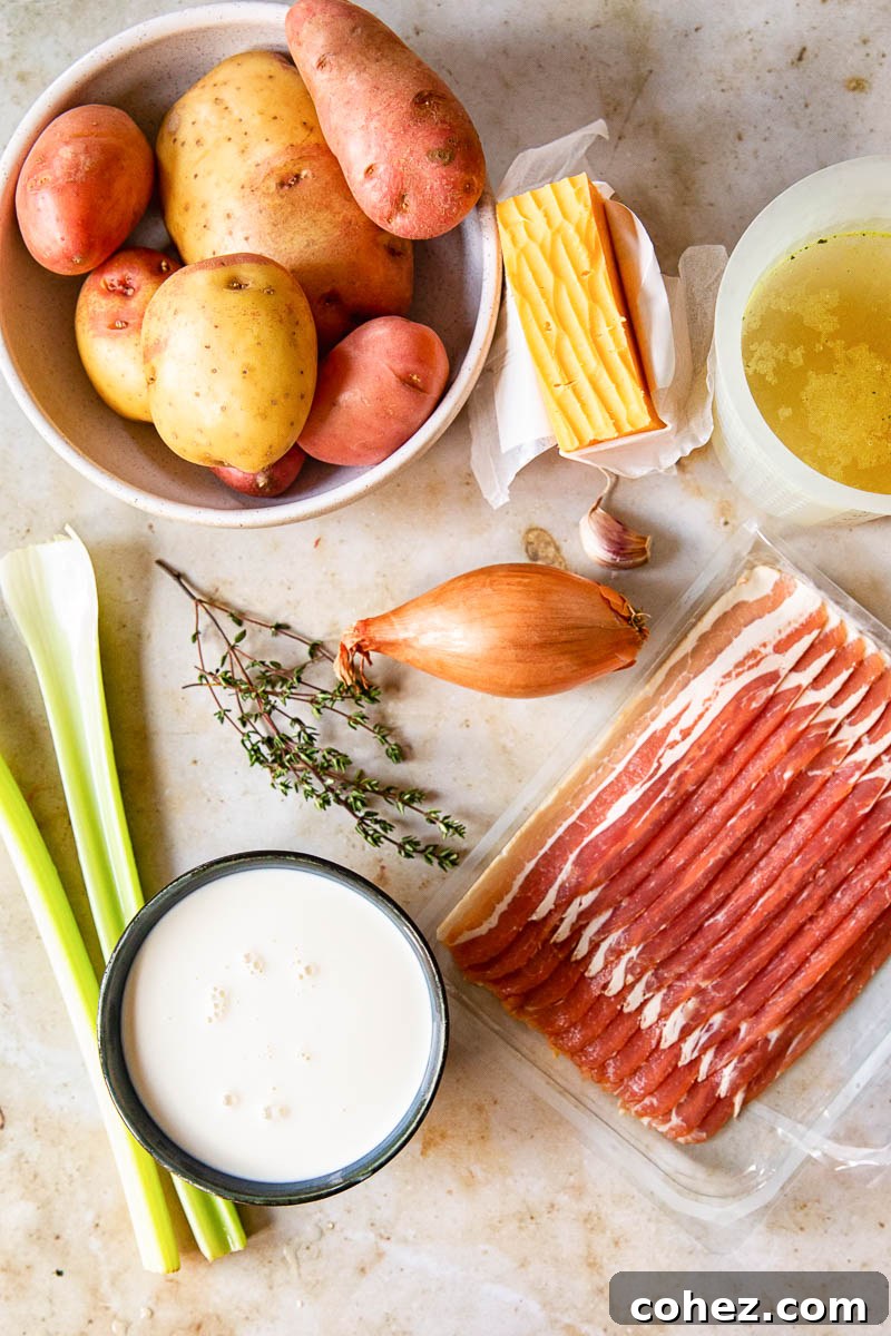 Assortment of fresh potato soup ingredients including Russet and red potatoes, celery, shallots, garlic, and thyme sprigs arranged on a wooden board.