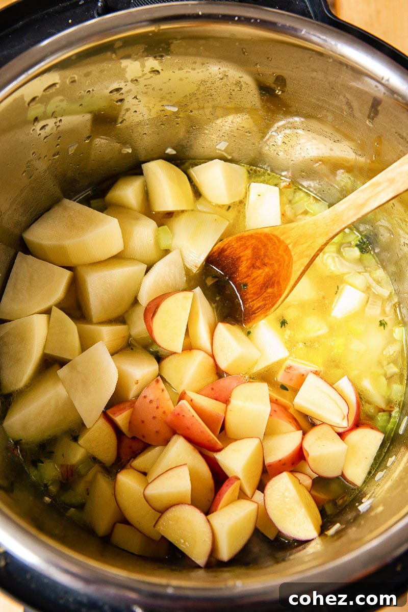 Cubed potatoes, celery, and shallots neatly placed inside an Instant Pot, ready for cooking to make a delicious soup.