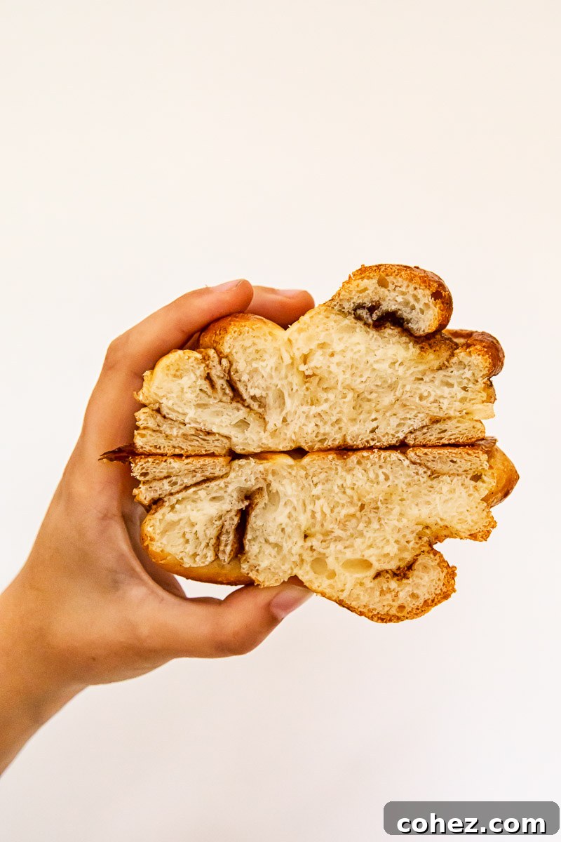 Cinnamon bun cut in half, revealing its soft, swirled interior and crumb structure
