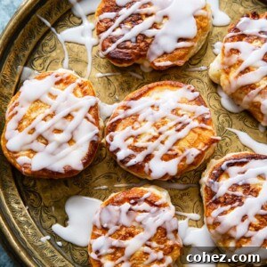 overhead view of apple fritters drizzled with sugar glaze on platter