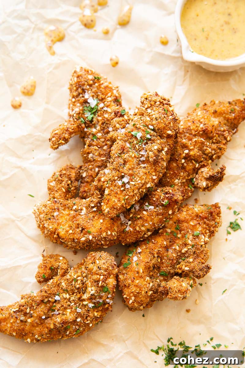 Golden Air Fryer Chicken Tenders and Tangy Honey Mustard 5 One perfectly crisp chicken tender ready to be dipped into a small dish of homemade honey mustard sauce.