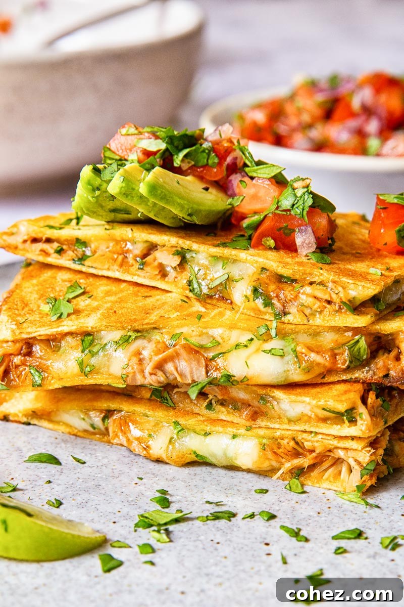 quesadilla pieces stacked on top of each other and topped with avocado and pico de gallo