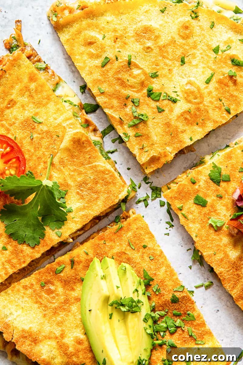 quesadilla cut in quarters and topped with sliced avocado close up