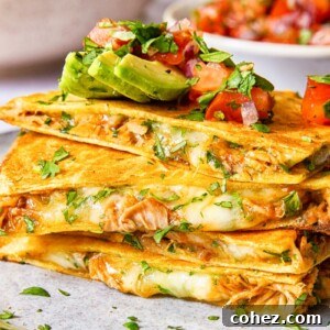 quesadilla pieces stacked on top of each other and topped with avocado and pico de gallo