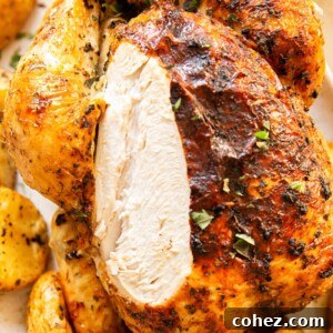 Carved roast chicken showing white meat, served on a platter.