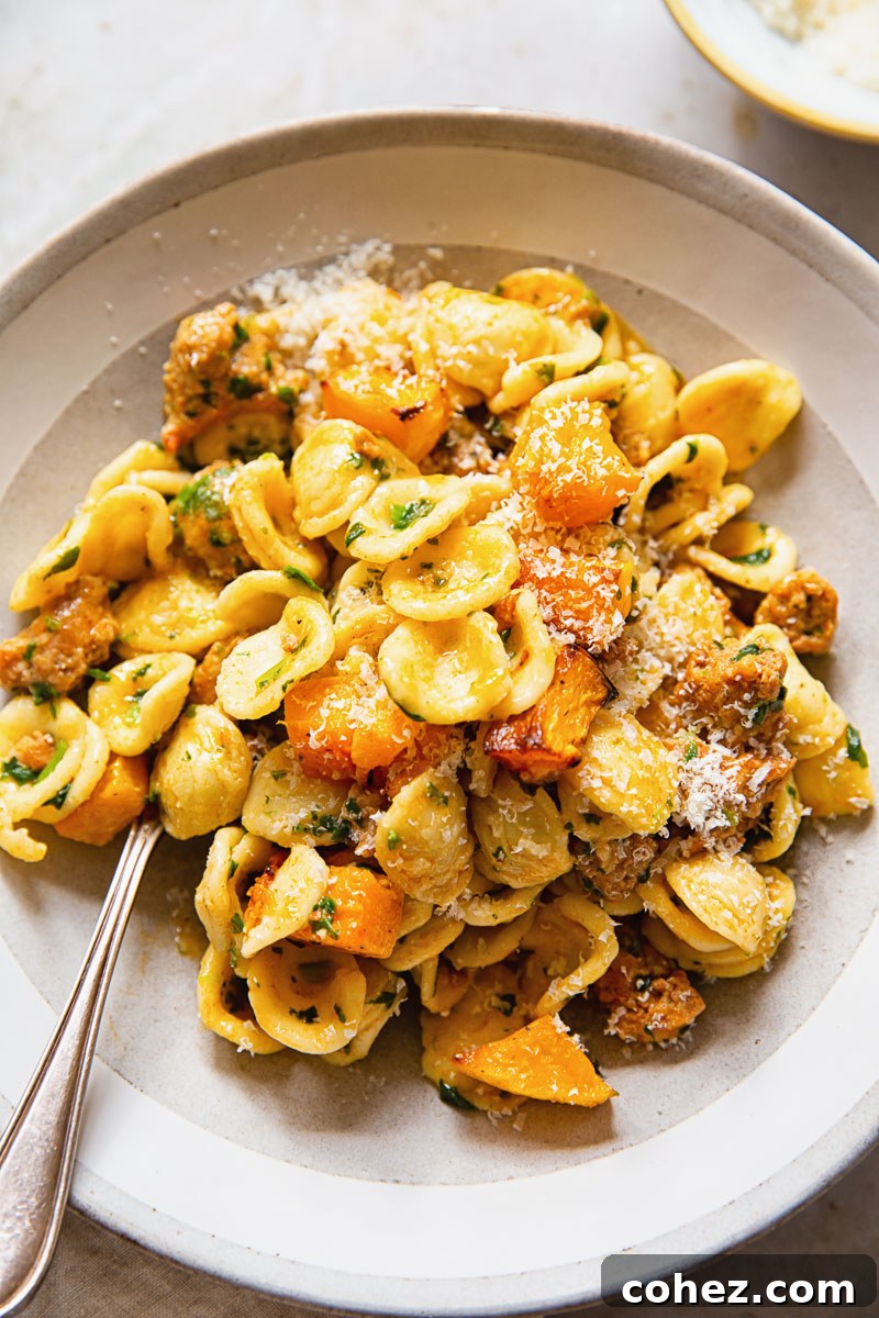 Delicious orecchiette pasta with roasted butternut squash in a cream bowl, garnished with fresh herbs