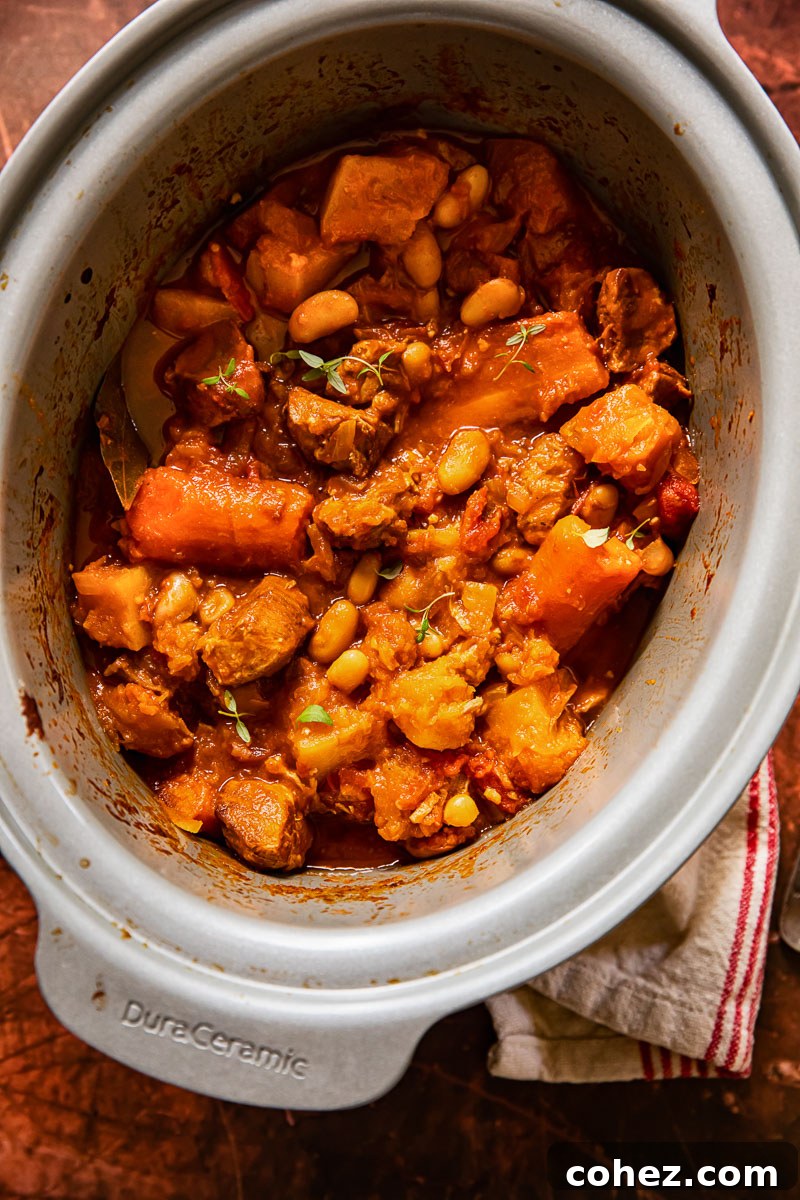 Hearty pork and vegetable stew simmering perfectly in a slow cooker, promising rich flavors and tender results.