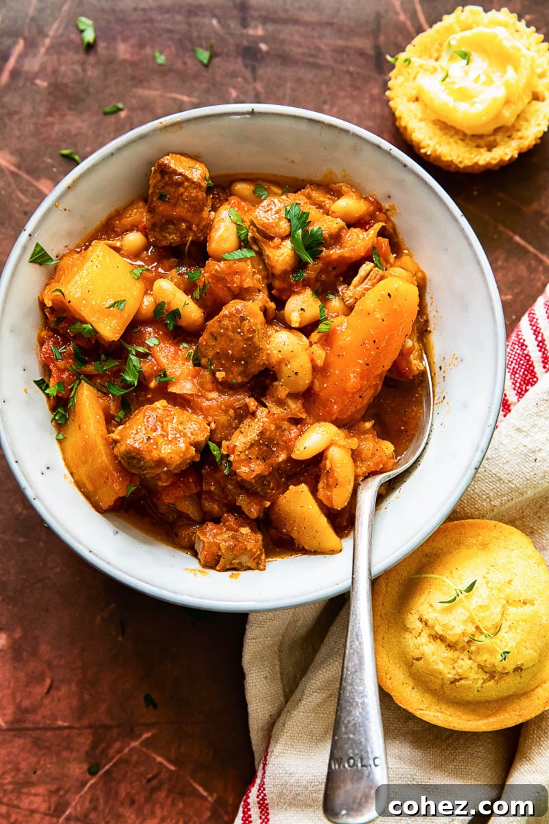 Delicious pork and vegetable campfire stew served in a bowl, accompanied by homemade cornbread muffins.
