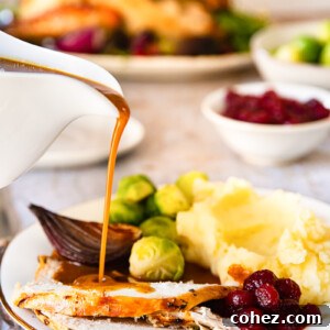 Rich homemade gravy being poured over slices of roast turkey