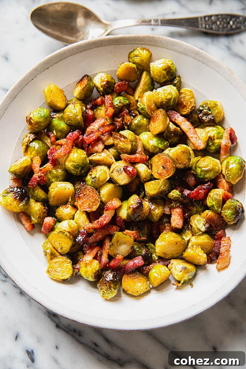 Brussels sprouts with bacon in a cream bowl on marble background
