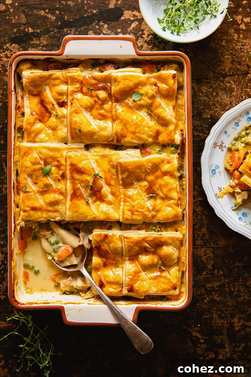 Golden Marsala Turkey Pie 5 Top-down view of the turkey pot pie with puff pastry on a rustic brown background, garnished with fresh herbs