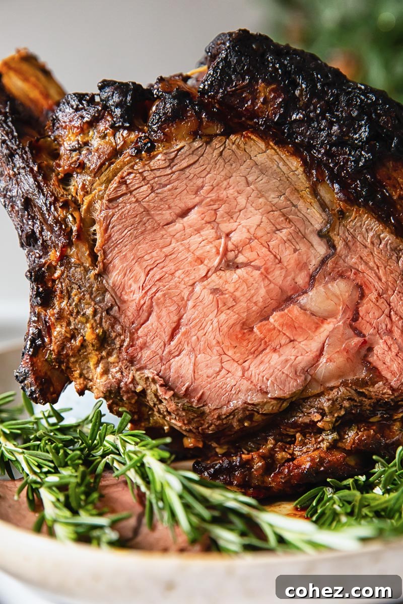 A slice of perfectly cooked prime rib roast revealing a beautiful pink, medium-rare interior.