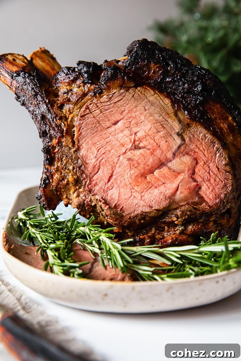 A magnificent Prime Rib Roast resting on a platter, garnished with fresh rosemary, ready to be carved and served.