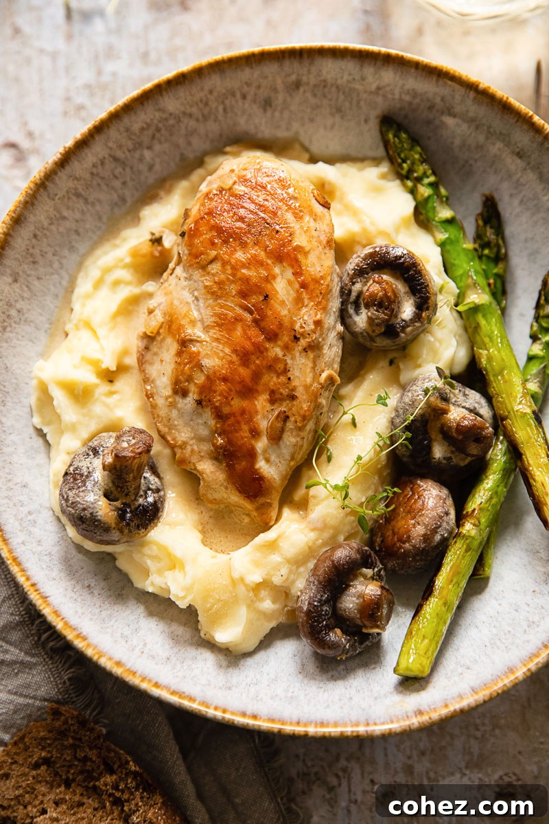 Supreme Chicken with Velvety White Wine Mushroom Sauce 3 Plated chicken supreme with mushrooms and cream sauce over a bed of mashed potatoes, garnished with fresh herbs and asparagus.