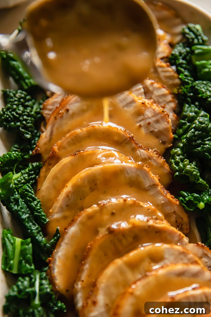 Succulent Pork Loin with Rich Pan Gravy 6 sliced pork loin roast with gravy being poured over it