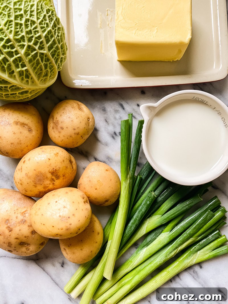 Ingredients for Colcannon: potatoes, green onions, milk, butter, and Savoy cabbage artfully arranged on a marble surface