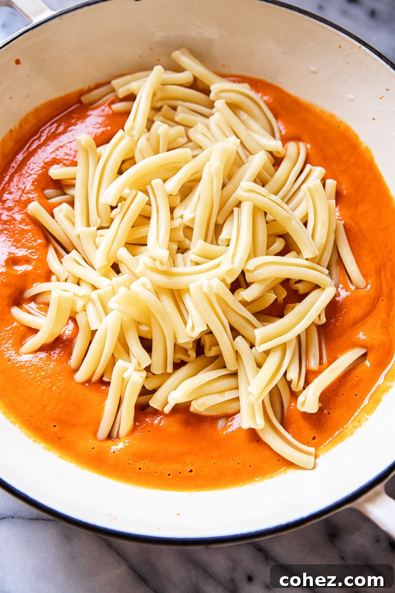 Velvet Vodka Pasta 3 A vibrant display of fresh and canned ingredients for vodka sauce, including ripe tomatoes, aromatic basil, fresh garlic, and a bottle of vodka, perfectly arranged to showcase quality.