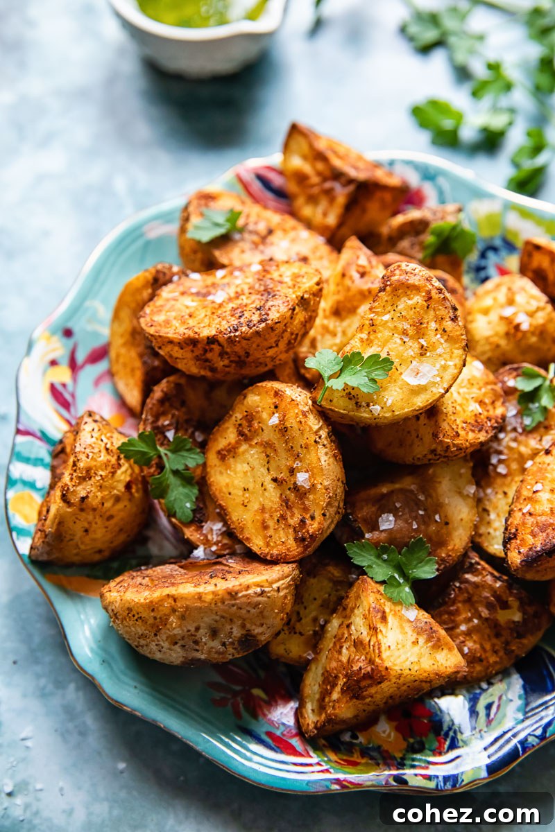 Golden Air-Fried Spuds 5 top down view of air fryer potatoes on blue plate, sprinkled with parsley