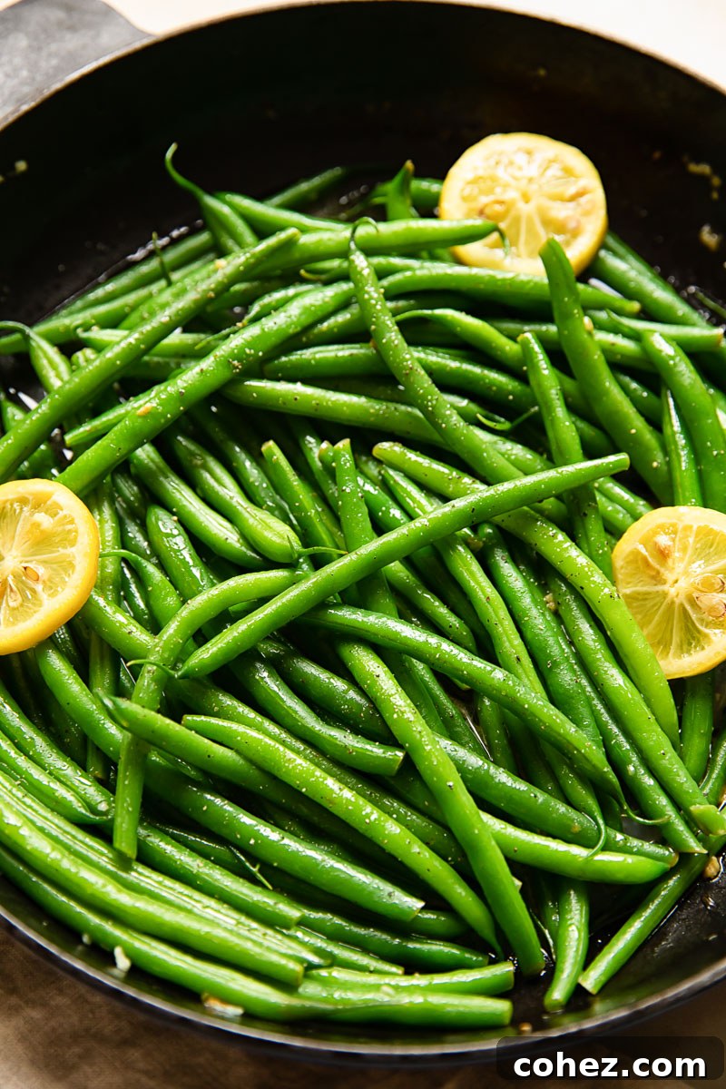 green beans with lemon slices in a cast iron pan