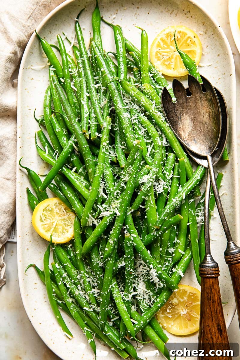 top down view of green beans with lemon slices and Parmesan