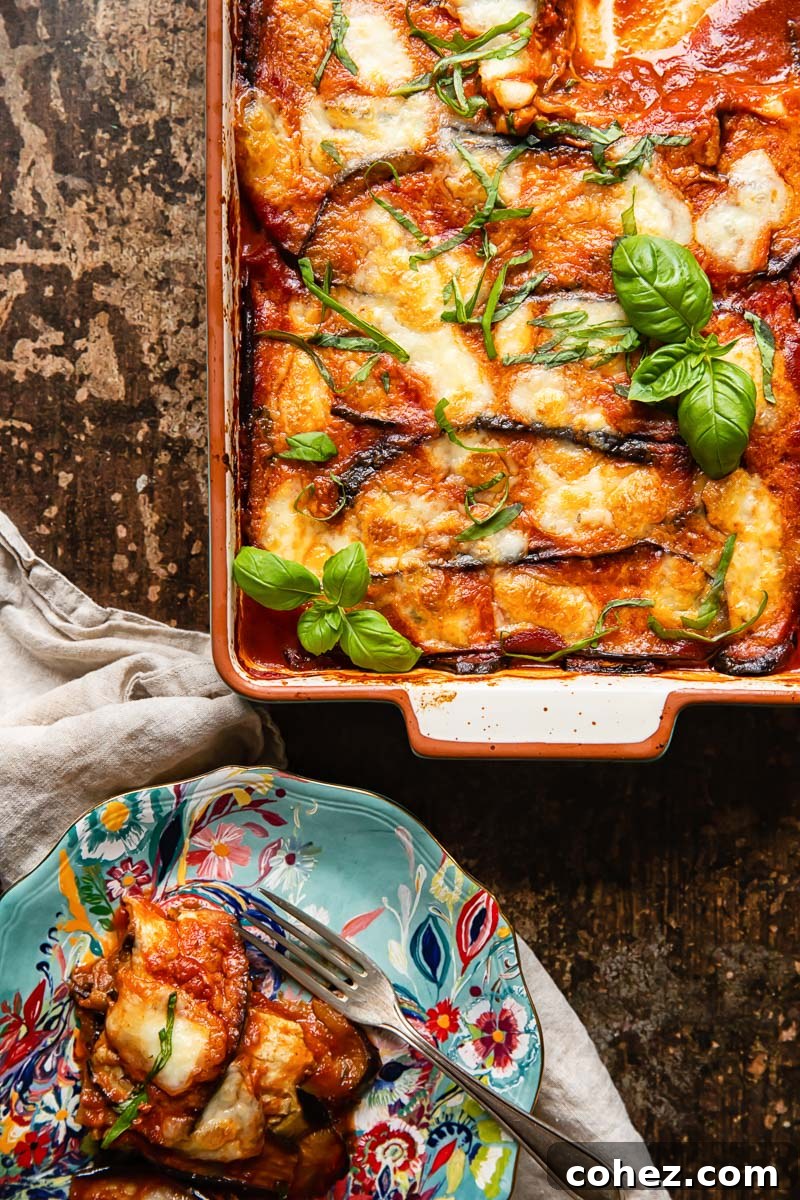 top down view of aubergine parmigiana in a pan and a portion on a blue plate