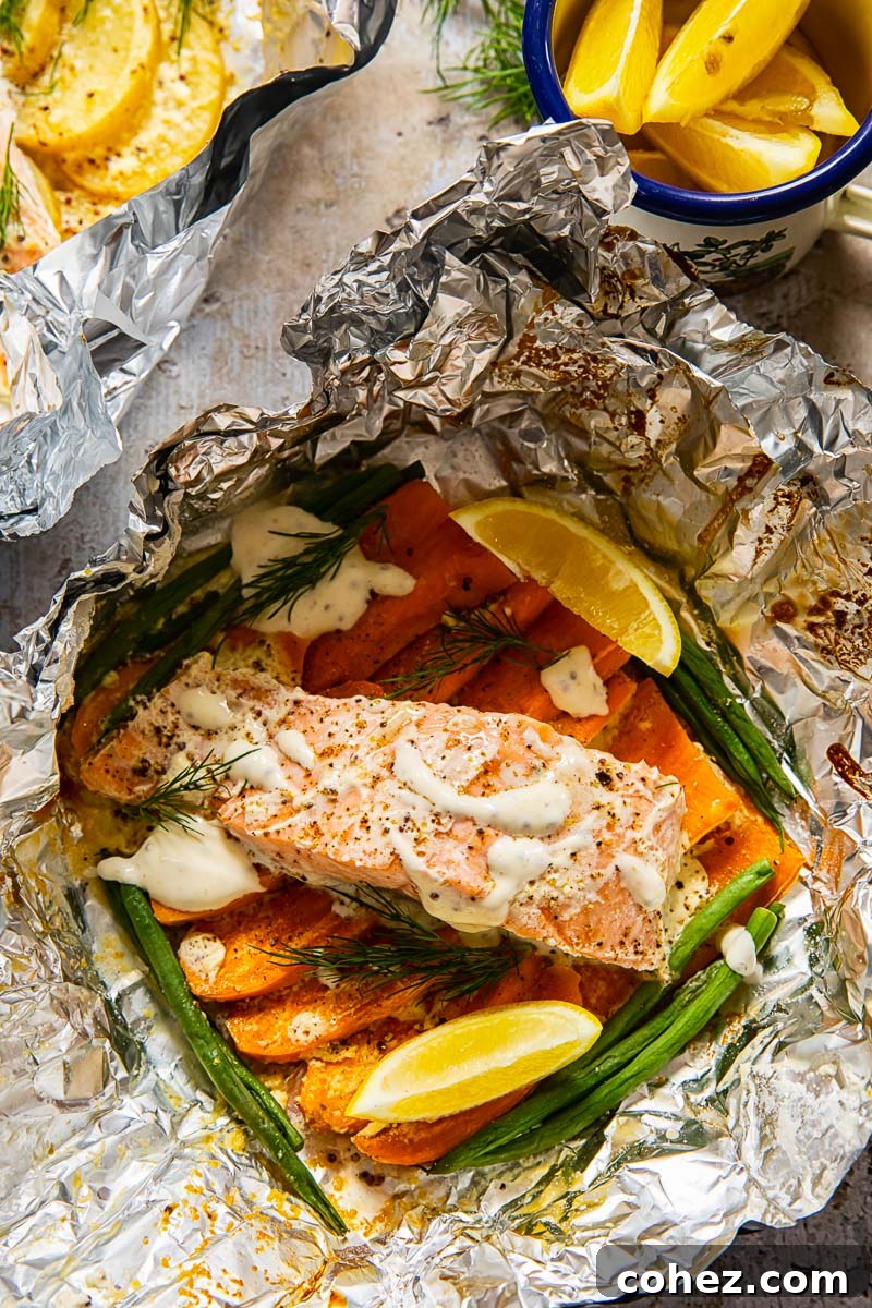 Hearty Salmon and Potato Foil Packs for Camp 3 Closeup of a foil packet meal showing flaky salmon, tender sweet potatoes, and vibrant green beans, ready for a healthy dinner.