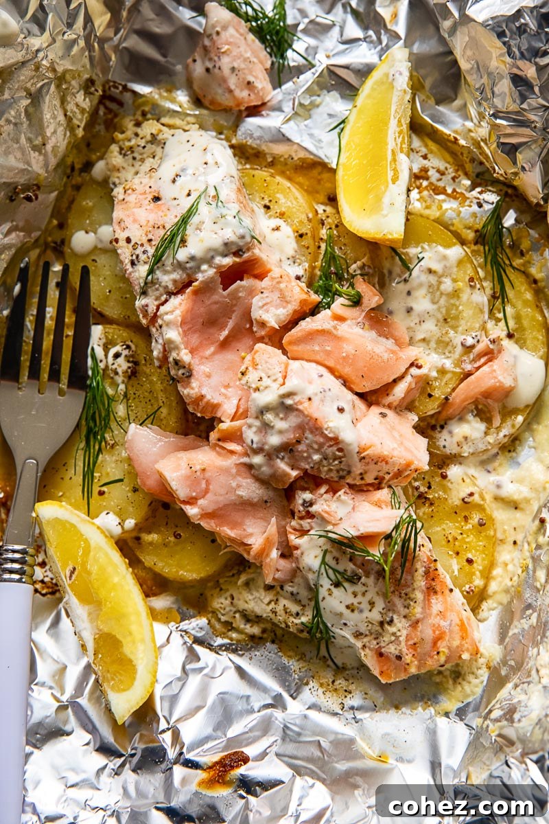 Hearty Salmon and Potato Foil Packs for Camp 5 Perfectly flaked salmon resting on tender potato slices in a foil packet, garnished with fresh lemon wedges, ready to be served.