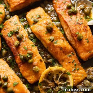 Pan seared salmon piccata, garnished with fresh capers and lemon slices, presented in a large skillet.