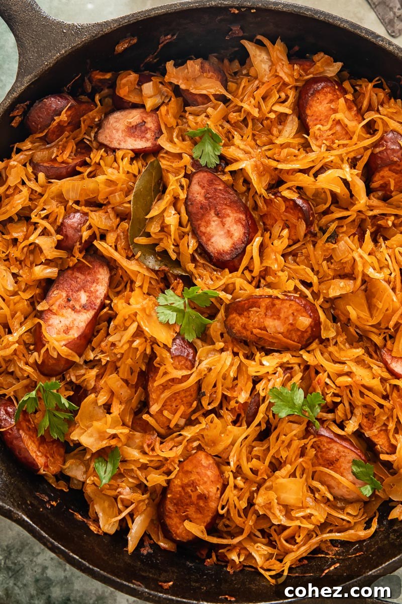 Rustic Kielbasa and Kraut Skillet 2 Smoky kielbasa and tangy sauerkraut cooking in a frying pan, ready to be served as a healthy and delicious meal.