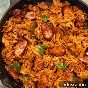 Top down view of kielbasa and sauerkraut in a frying pan, ready to be served.