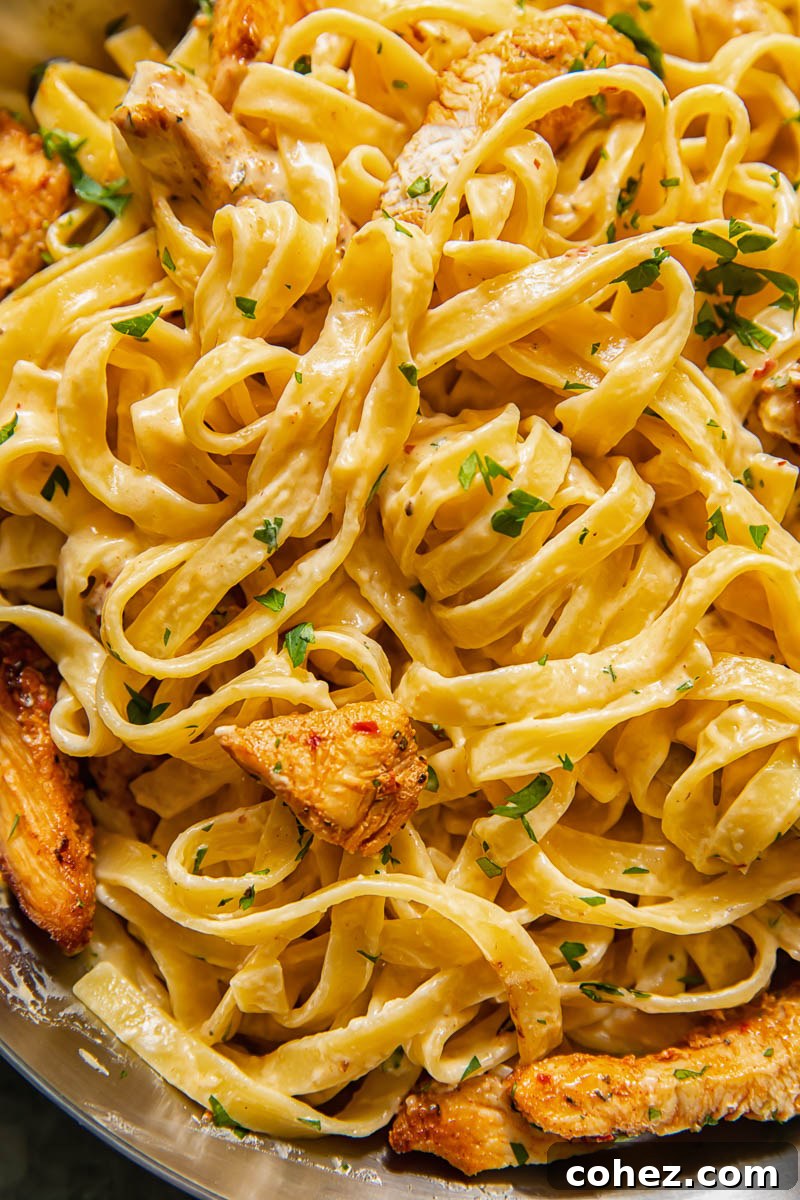 A close-up view of Cajun Chicken Alfredo pasta, highlighting the creamy sauce and tender chicken pieces.