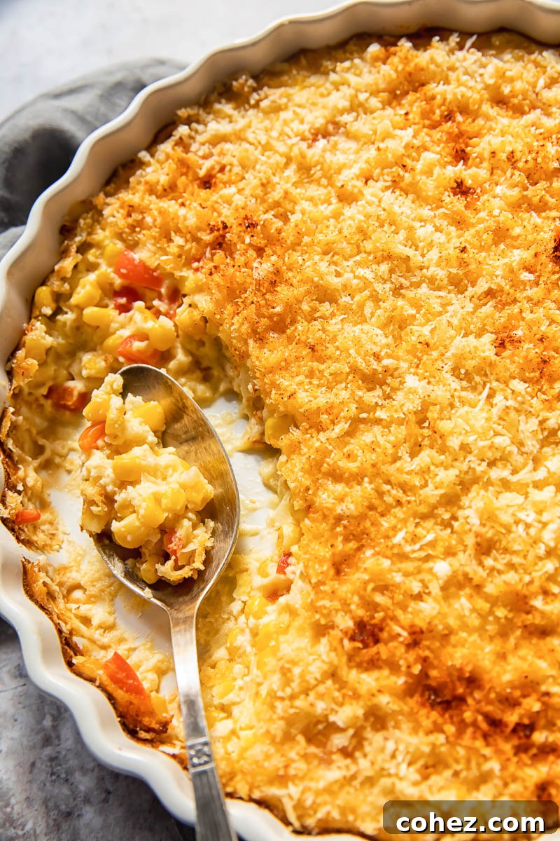 creamy corn bake in a white round dish with a spoon in it
