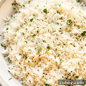 A bowl of fluffy coconut rice garnished with fresh cilantro, ready to be served.