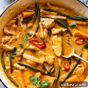 Thai red curry with chicken, sweet potatoes and green beans in a white pan
